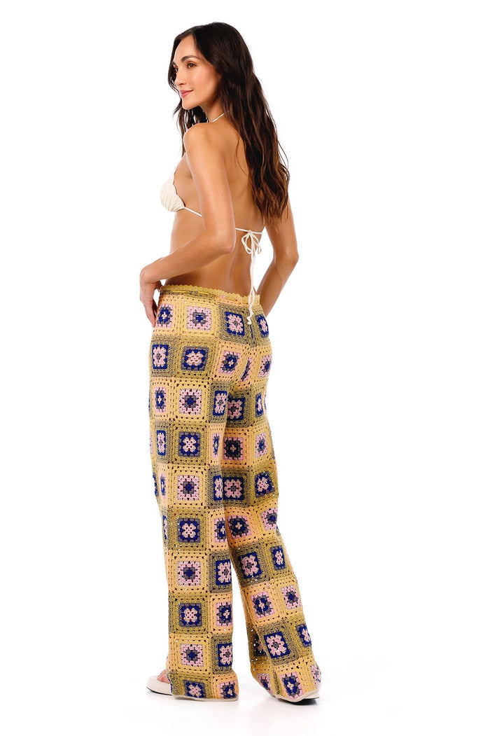 Crochet-look pants in golden yellow with colorful granny square pattern featuring blue, pink, and purple pattern detail centers