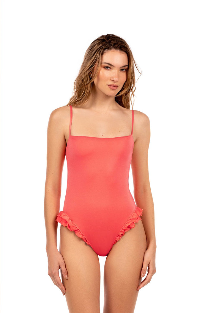 Coral one-piece swimsuit with straight neckline, thin adjustable straps, and ruffle trim along leg openings