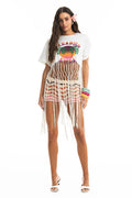 White fringe cover-up with Paradise graphic featuring sunset circle, palm trees, and long macramé fringe hem