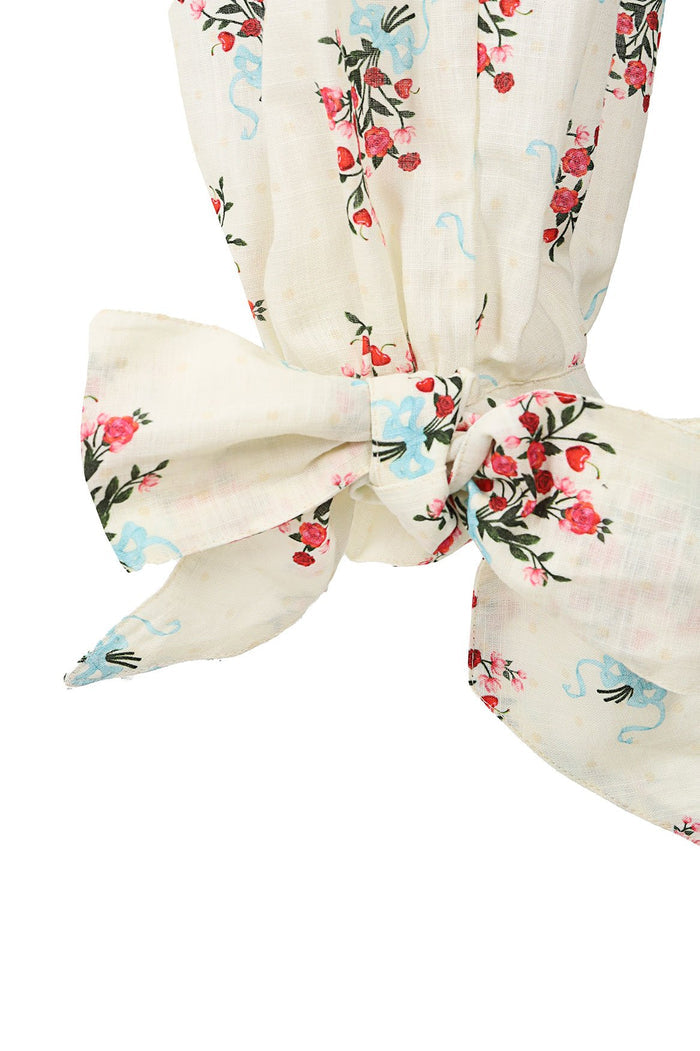 Cream linen pants with floral embroidery featuring pink and red roses, green leaves, and light blue decorative swirls, tied at ankle with fabric bow