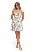 White mini dress with pattern detail print featuring blue scrollwork and coral blooms, structured bodice with sweetheart neckline and shoulder straps