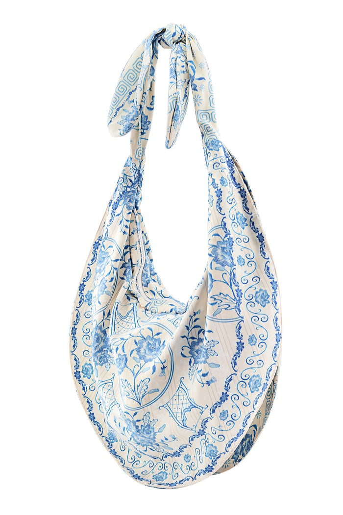Tali Bag in cream with blue pattern detail and scrollwork print, featuring knotted top handle and relaxed slouch silhouette