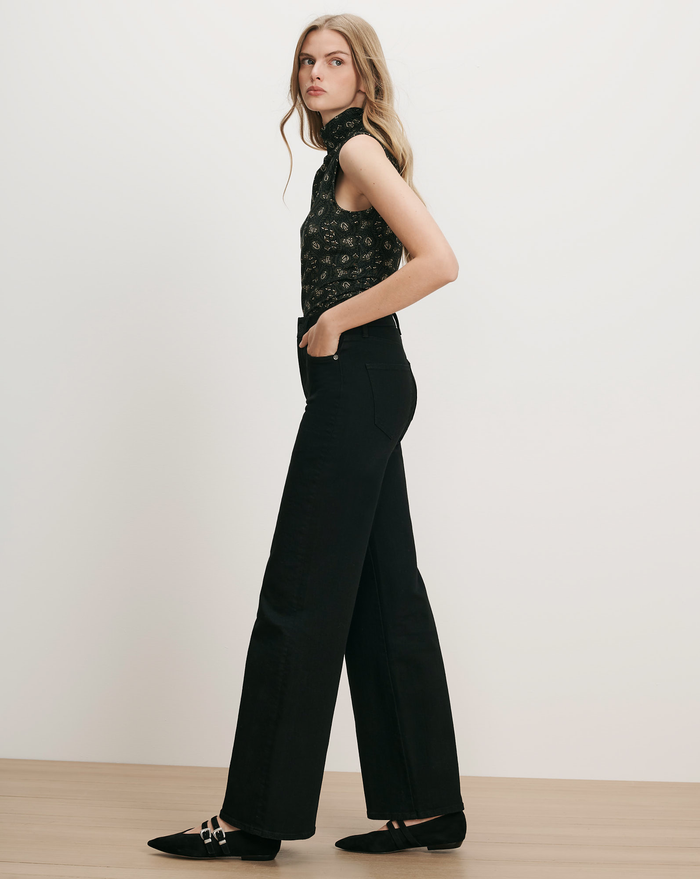 Veronica Beard Black floral sleeveless turtleneck, black wide-leg jeans.