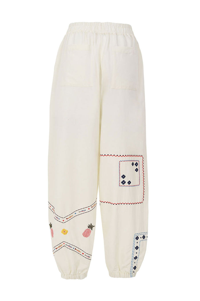 Toscana pants in cream with embroidered pattern detail details, zigzag trim, and pineapple placement print at hem with elastic waist and cuffs