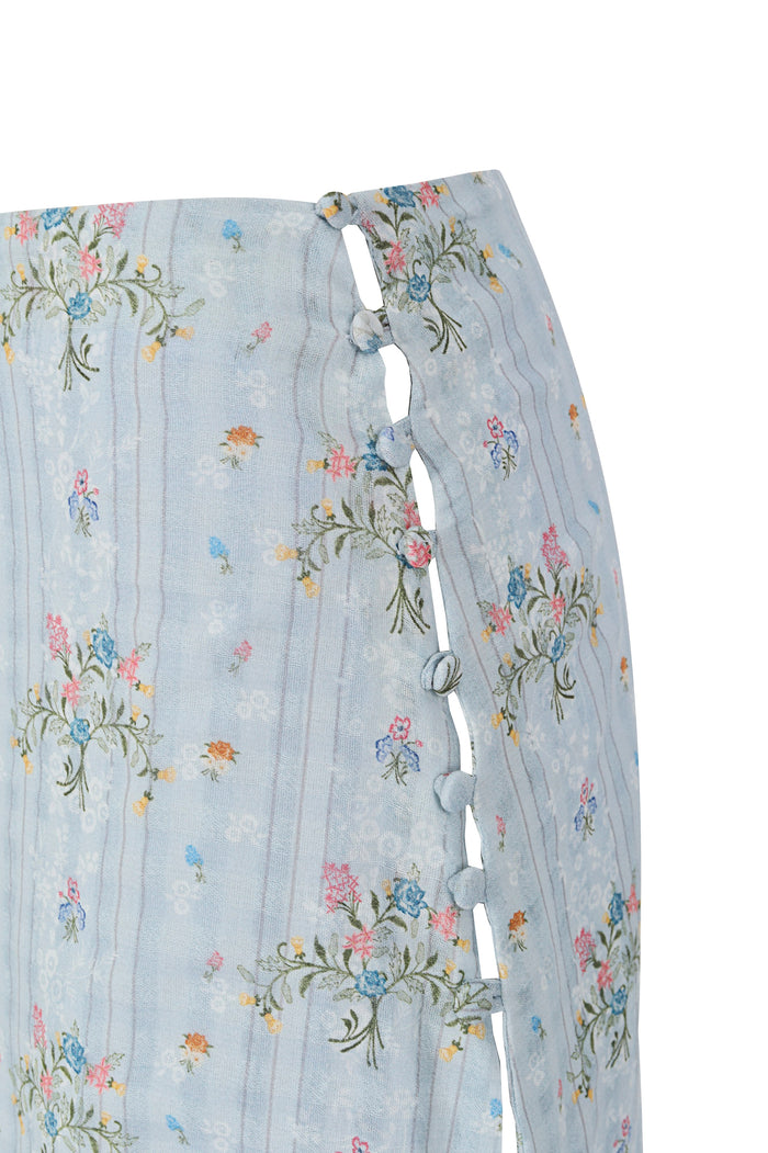Light blue midi skirt with embroidered pattern detail print, side button closures, lace trim, and high leg slit