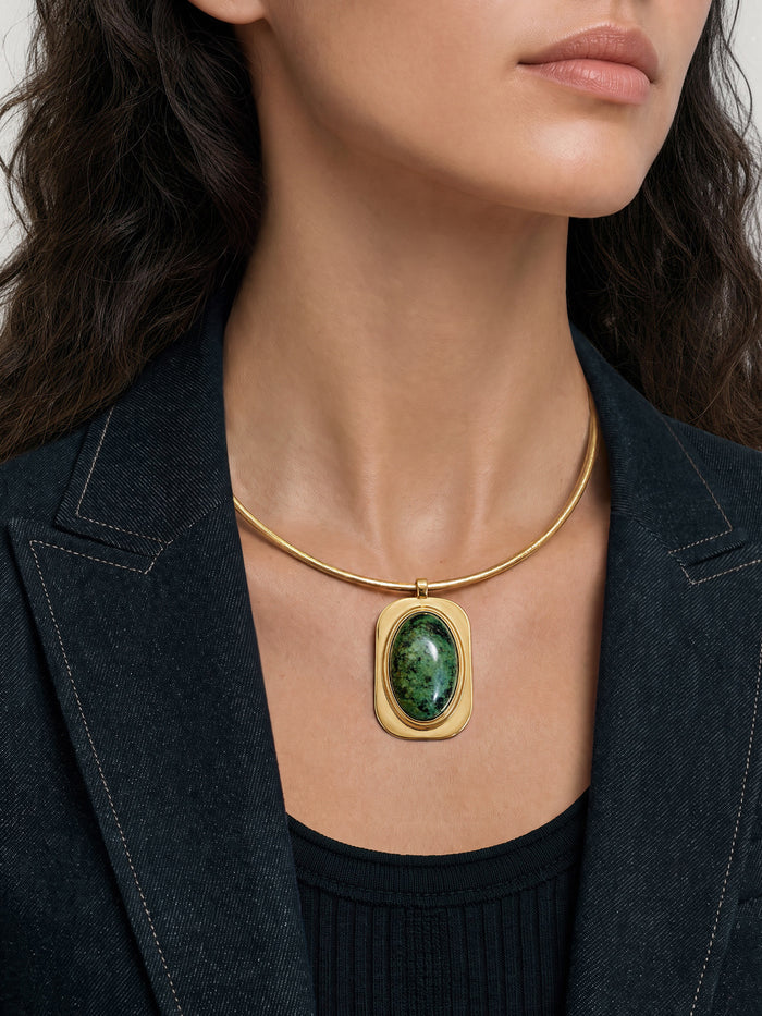Veronica Beard Gold necklace with large green stone pendant.