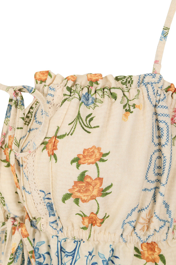 Vichy crop top in cream with orange pattern detail print, blue cross-stitch embroidery, adjustable lace front tie, and ruched neckline