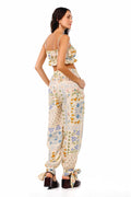 Zadia pants in cream with patchwork print featuring orange fruits, blue florals, geometric patterns, lace details and adjustable ankle ties