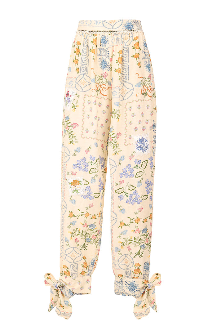 Zadia wide-leg pants in cream with pattern detail embroidery, geometric patterns, and adjustable ankle ties with lace trim