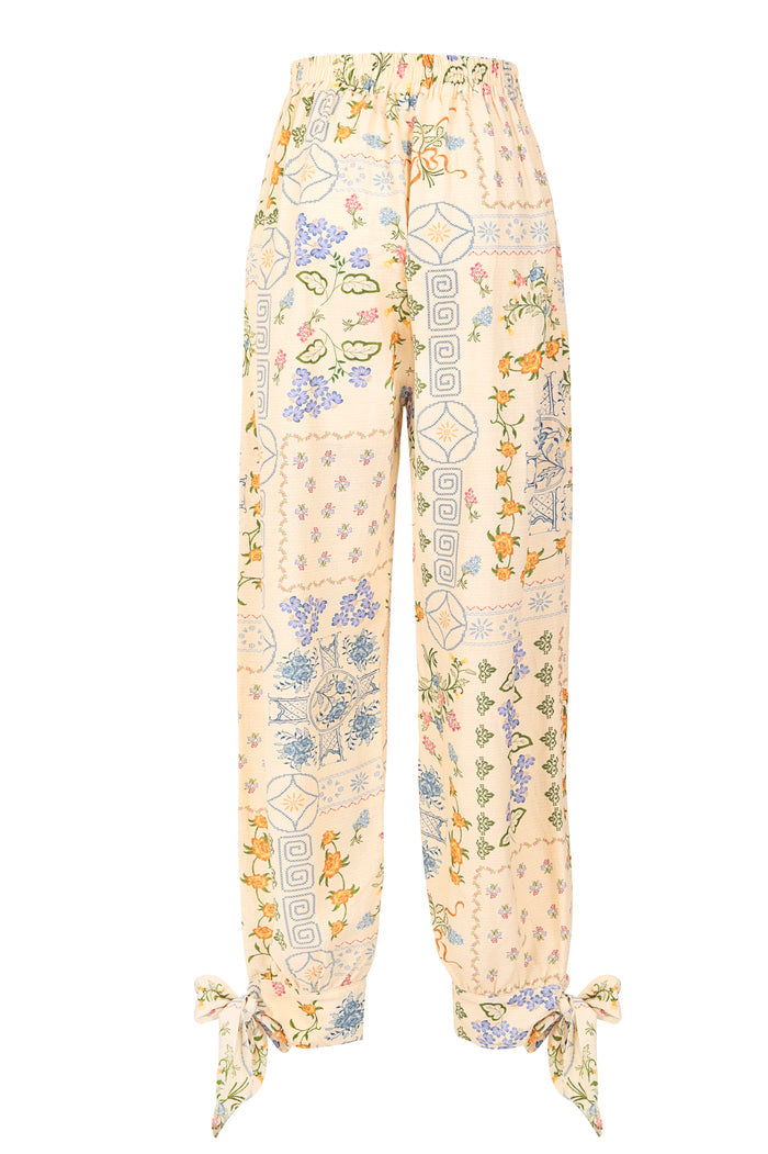 Zadia pants in cream with patchwork print of pattern detail embroidery, geometric patterns, and tie straps at ankles