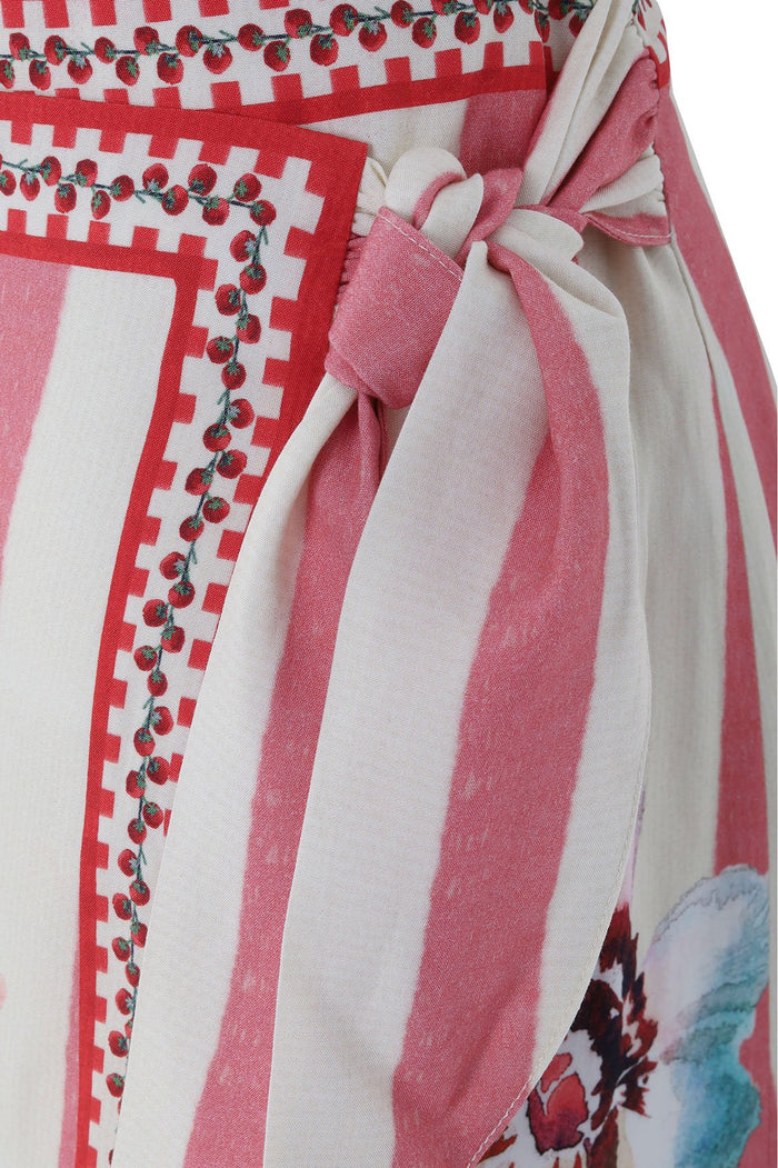 Ziara wrap pareo in red and pink vertical stripes with checkered pattern trim and red circular embellishments, featuring fabric tie closure at waist